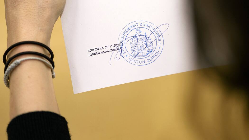 Politik will Schuldnertourismus stoppen Eine Frau betrachtet einen Betreibungsregisterauszug mit einem Stempel drauf.