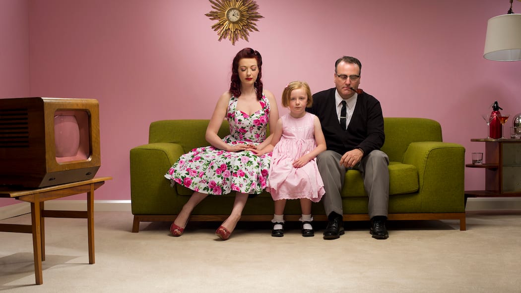 Kind da, Liebe weg Familie mit Kind im 50er-Jahre Stil auf einem Sofa. Eltern zu sein ist wunderbar. Doch die Paarbeziehung leidet oft darunter. Tipps, wie es nicht zur Trennung kommt.