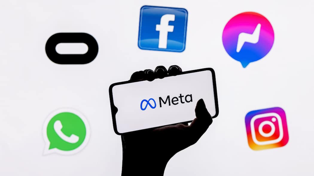 Facebook und Instagram: So schützen Sie jetzt Ihre Daten Eine Hand hält ein Smartphone in die Höhe auf dem «Meta» steht. Rundherum schweben die Logos von Instagram, Whatsapp, Messenger und Facebook.