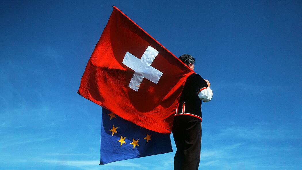 Die neuen EU-Verträge – kompakt und verständlich Fahnenschwinger mit Schweizer- und EU-Flagge - Fast 2000 Seiten dick sind die Verträge, die der Bundesrat mit der Europäischen Union abschliessen will. Was steht drin? Was ändert sich? Der Beobachter erklärt