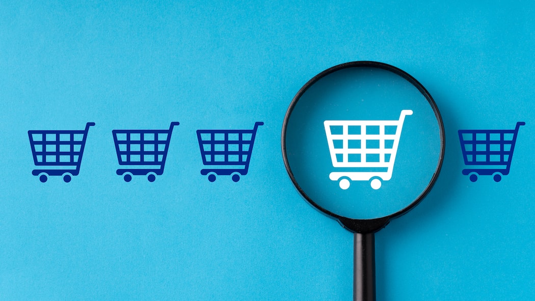 Künstliche Intelligenz erkennt unseriöse Webshops Eine Lupe vor vier blauen und einem weissen Einkaufswagen auf blauem Hintergrund. Künstliche Intelligenz auf fakeshopfinder.de erkennt unseriöse Webshops.