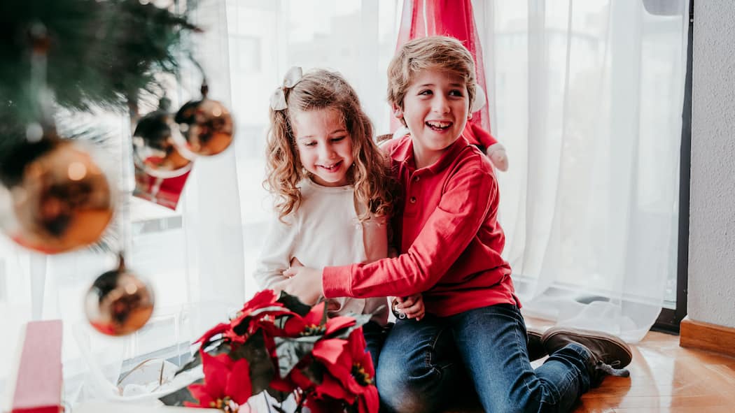 Mehr Luft unterm Baum! Zwei kleine Geschwister freuen sich sichtlich über ihr Weihnachtsgeschenk.