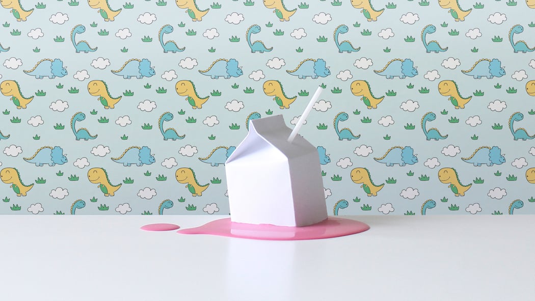 Diese Säfte für Kinder sind reine Zuckerbomben Ein weisser Tetrapak steht auf einer süssen lilafarbigen Flüssigkeit vor einer Tapete mit Dinosaurier-Motiven. Die Industrie bewirbt Getränke speziell für Kinder. Doch diese sind für eine gesunde Kinderernährung eher nachteilig.