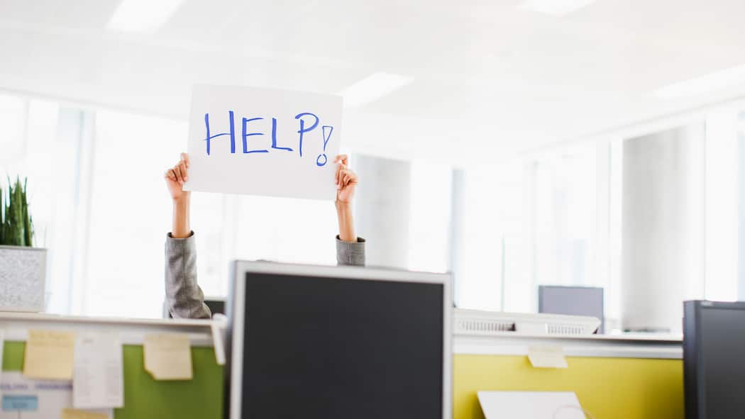 So muss Sexismus im Betrieb richtig aufgearbeitet werden Frau hält im Büro eine Schild mit dem Schriftzug Help hoch. Wenn der Vorwurf des Mobbings oder der sexuellen Belästigung im Raum steht, müssen Arbeitgeberinnen dem nachgehen – und dabei die Rechte der Beteiligten wahren.