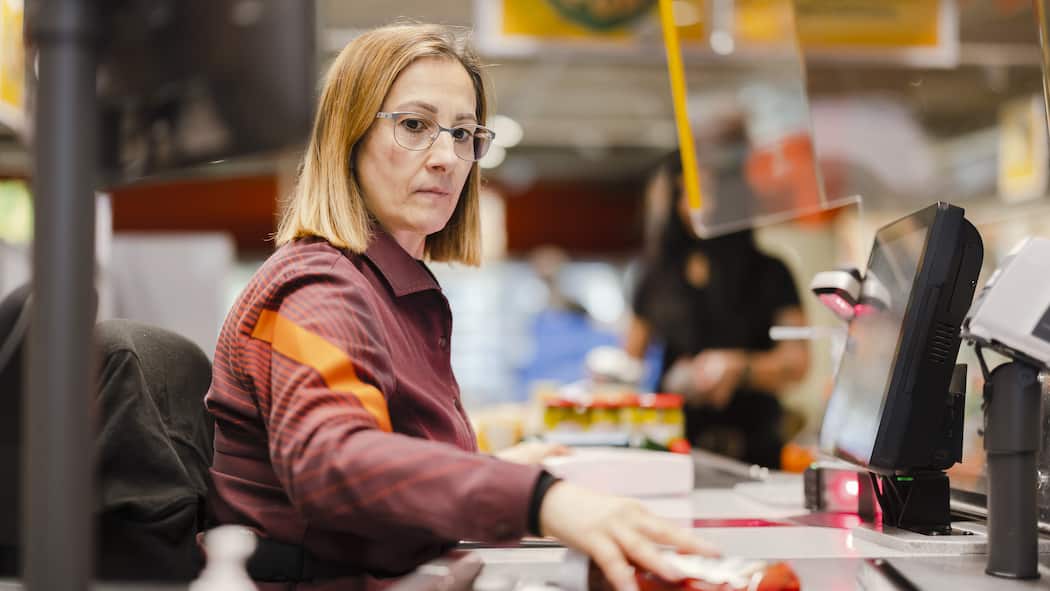 Schluss mit Kassenzetteln! Eine Verkäuferin scannt Produkte an der Kasse der Migros. Bei der Migros gibt es einen Kassenbon nur noch, wenn man danach fragt. Doch: Wie kann man da beweisen, dass man die Waren nicht geklaut hat?