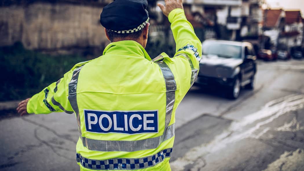 Nach den Ferien folgt die Busse Ein Verkehrspolizist im Ausland steht an einer Strasse und winkt einen Autofahrer zur Kontrolle heraus. Das sollten Sie tun, wenn Sie im Ausland eine Busse kassiert haben.