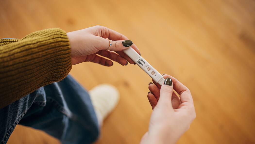 Schwangerschaftsabbruch – was in der Schweiz gilt Eine Frau hält einen positiven Schwangerschaftstest in den Händen