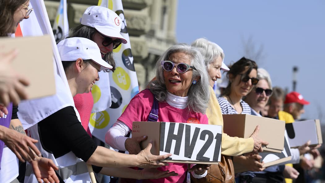 Sollen auch Frauen bis 65 arbeiten? Personen uebergeben die Schachteln mit Unterschriften, waehrend die uebergabe der Unterschriften fuer das Referendum gegen die AHV-Reform, am Freitag, 25. Maerz 2022, vor der Bundeskanzlei, in Bern. (KEYSTONE/Anthony Anex)
