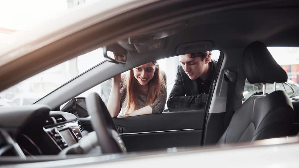 Warum Sie beim Occasionskauf nach der Herkunft fragen sollten Junges Paar schaut in ein Auto - Ein Kunde kauft eine Occasion. Erst nach hartnäckigem Nachfragen erfährt er, dass es ein Mietauto war. Die Garage hat trotzdem nicht gesetzeswidrig gehandelt