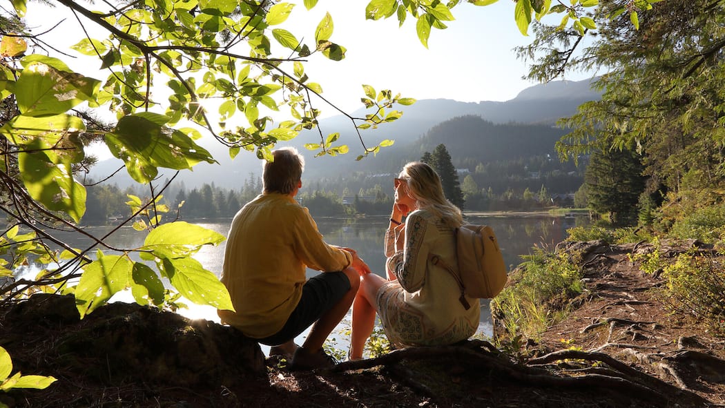 Mit 55 raus aus dem Job? So viel Kapital brauchen Sie Ein älteres Paar sitzt in an einem See - Früher aufhören zu arbeiten gilt als Inbegriff von Freiheit. Doch zwischen Theorie und Realität klafft eine Lücke von Millionen. Wir zeigen, mit welchen Summen Sie tatsächlich rechnen müssen