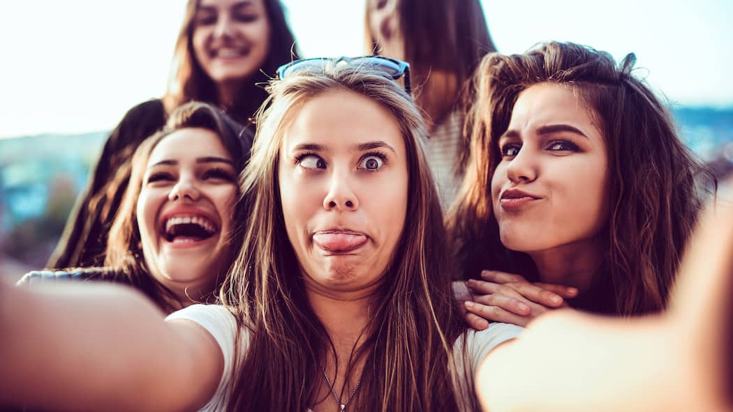 Baustelle Pubertätshirn Eine Gruppe junger Teenager-Mädchen steht zu einem Selfie-Bild zusammen und schneidet dabei alberne Grimassen.