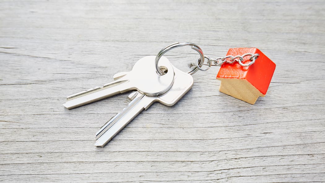 So zügelt die Kaution mit Ihnen Ein Schlüsselbund mit einem roten kleinen Haus liegt auf einem Holztisch. Wer aus der Mietwohnung auszieht, sollte auch die Mietkaution zurückbekommen. Bis wann hat man das Geld?