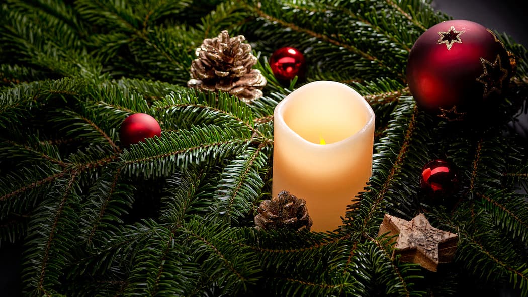 Advent, Advent, ein LED brennt Tannenzweige mit einer LED-Kerze, Tannzäpfen und roten Weihnachtskugeln