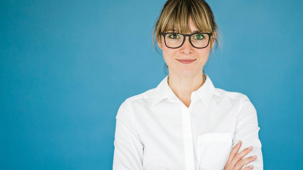 Sprache der Jobinserate schreckt oft Frauen ab Frau mit weissem Hemd und verschränkten Armen