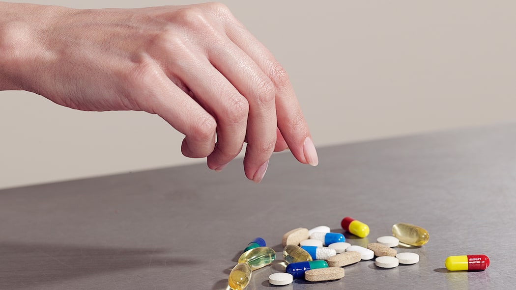 Wie süchtig machen Antidepressiva? Eine Frau greift nach einer Handvoll Tabletten
