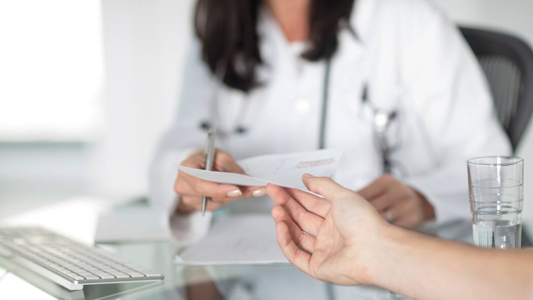 So erkennen Sie Fehler in der Abrechnung Ärztin überreicht Abrechnung an Patienten