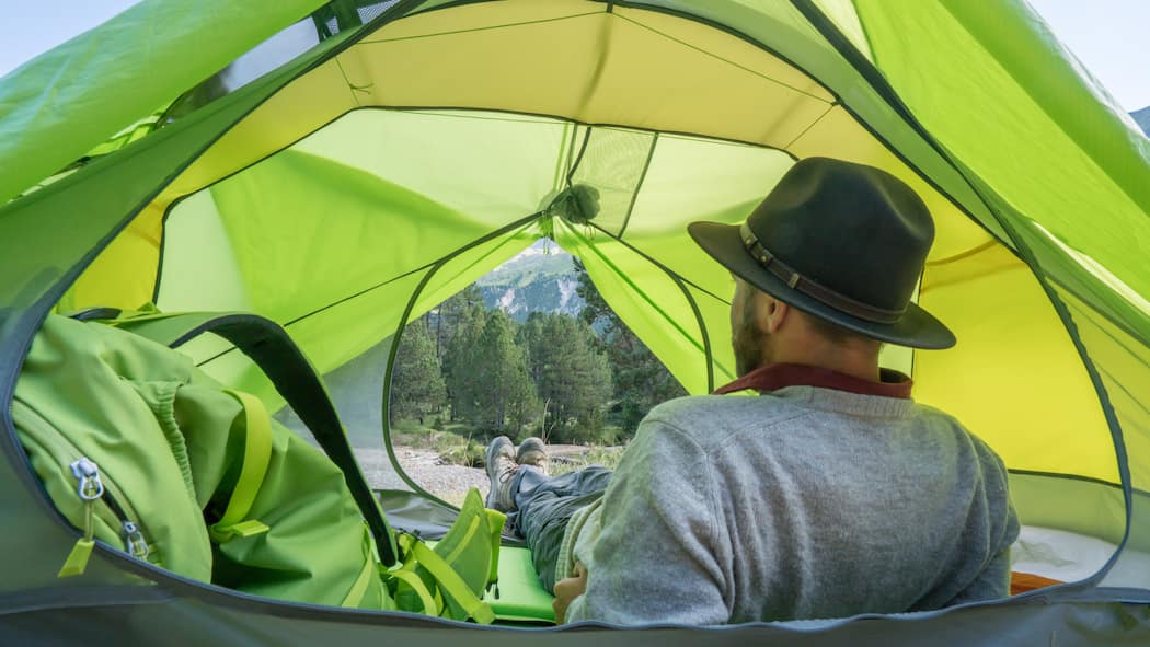 Hier können Sie wild campen – ohne Ärger oder Bussen Mann blickt aus dem Zelt: Einfach irgendwo das Zelt aufzuschlagen, ist vielerorts verboten. Eine Übersicht zeigt, in welchen Kantonen es verboten ist und was wo erlaubt ist