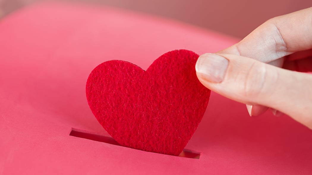 Geld spenden und vom Steuerabzug profitieren – das gilt Ein Herz wird in eine Sparbox gesteckt. Wer etwas spendet, erhält Steuervergünstigungen vom Staat.