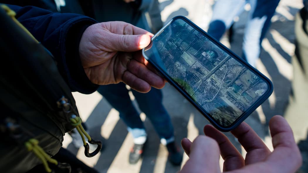 Bleiben Sie skeptisch! Eine Person schaut sich Aufnahmen eines Smartphones an, auf dem militärische Panzer zu sehen sind.