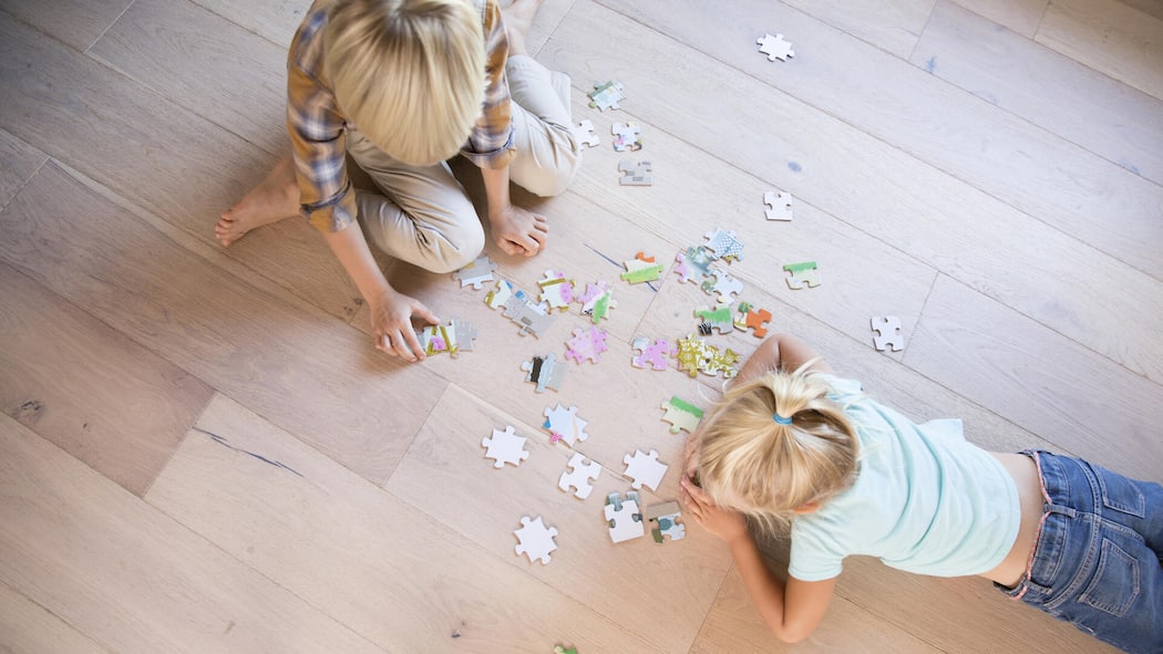 Platz da für Geschenke! So gelingt das grosse Ausmisten vor Weihnachten USA, Kalifornien, Pasadena, Hause, Wohnzimmer, Portrait, Familie, Junge und Maedchen liegen auf dem Boden und puzzeln1125574127