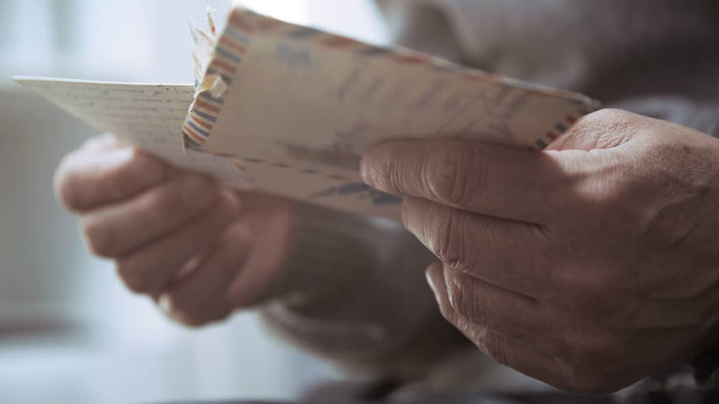 Das Millionenerbe eines unbekannten Verwandten Älterer Mann hält Couvert in der Hand