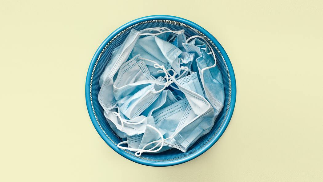 Weshalb Omikron die Pandemie beenden könnte Eimer mit gebrauchten Schutzmasken