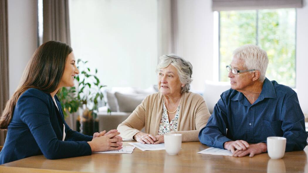 Letzte Fehler vermeiden Ein Senioren-Paar (Frau und Mann) sitzen am Tisch im Gespräch mit einer Beraterin