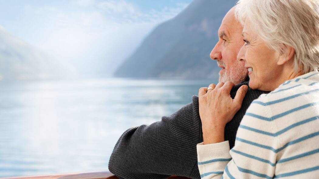 Rente oder Kapital – das ist hier die Frage Ein pensioniertes Ehepaar geniesst den Ruhestand und lässt den Blick über einen See schweifen.