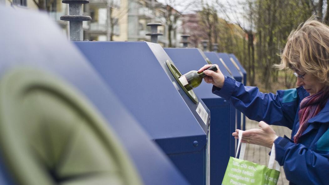 Die Recycling-Lüge Frau wirft in Zürich Altglas in den Recycling-Container