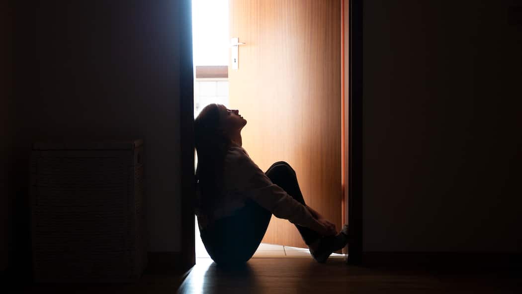 «Sie wollen nicht sterben» Trauriges Teenager-Mädchen sitzt auf dem Boden vor der Zimmertür