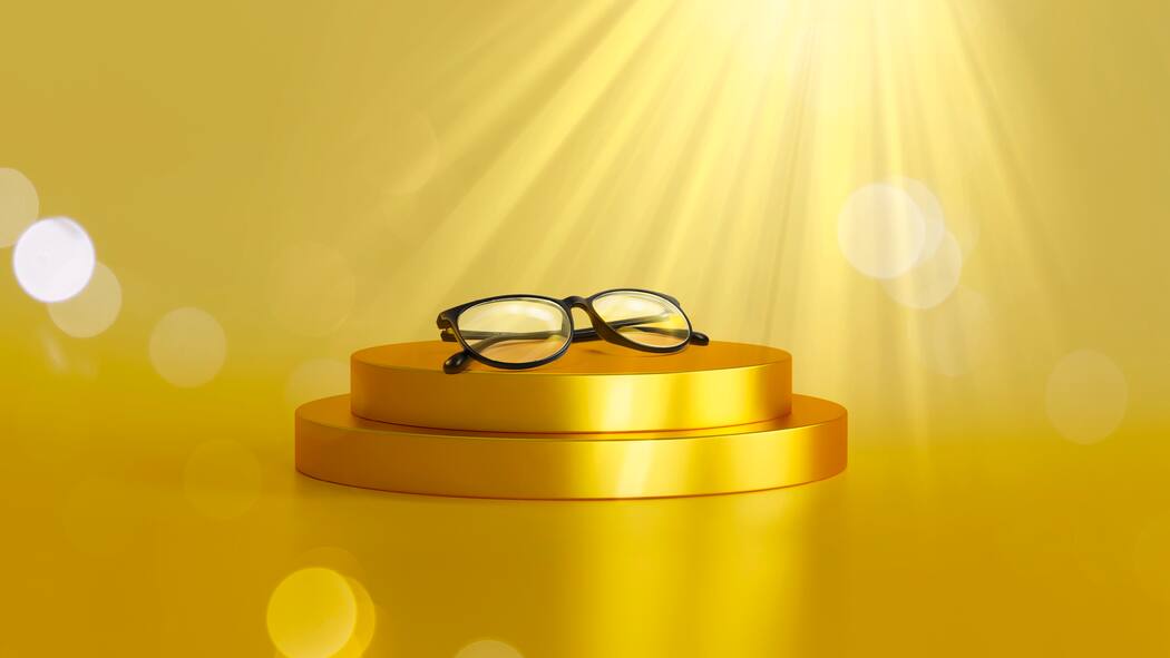 Wo fängt Luxus an? Brille auf goldenem Podest vor goldenem Hintergrund