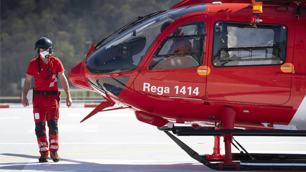 Die Hilfsorganisationen und ihre Millionen Notarzt neben Rega-Helikopter