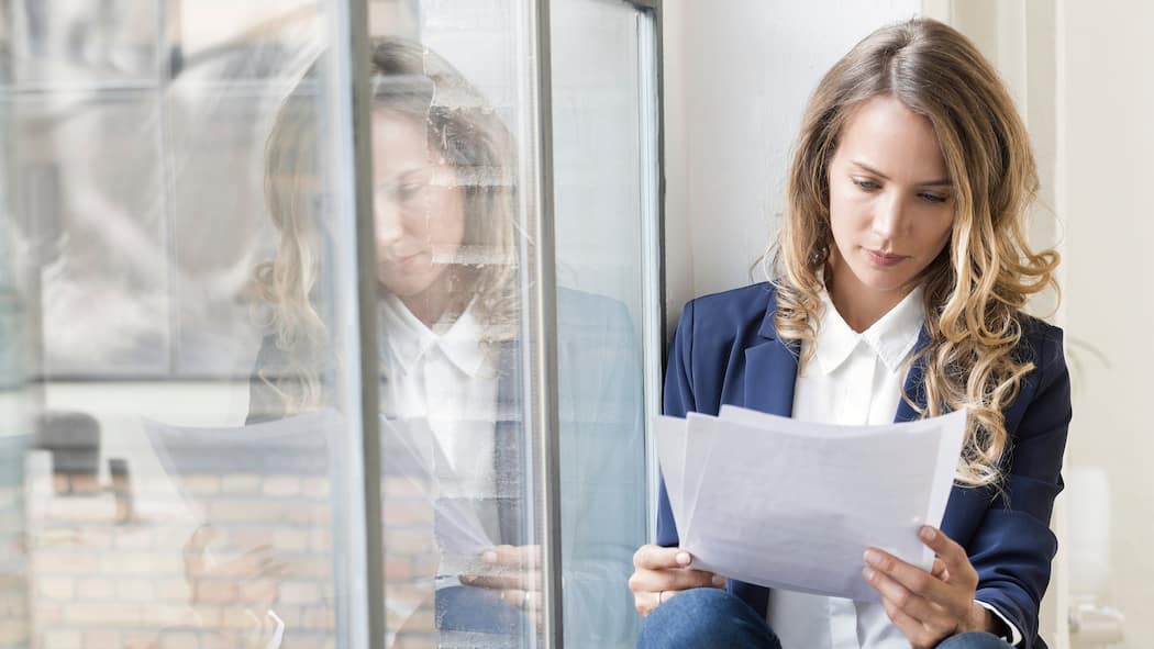 Weg vom Job, aber mit Zeugnis Eine Frau sitzt auf dem Fenstersims und liest ihr Zwischenzeugnis durch - Wer vom jetzigen Job weg will, legt für die Stellenbewerbung am besten ein Zwischenzeugnis vor. Doch wie geht man vor, damit die Chefin nichts davon erfährt? Die Tipps des Beobachters.