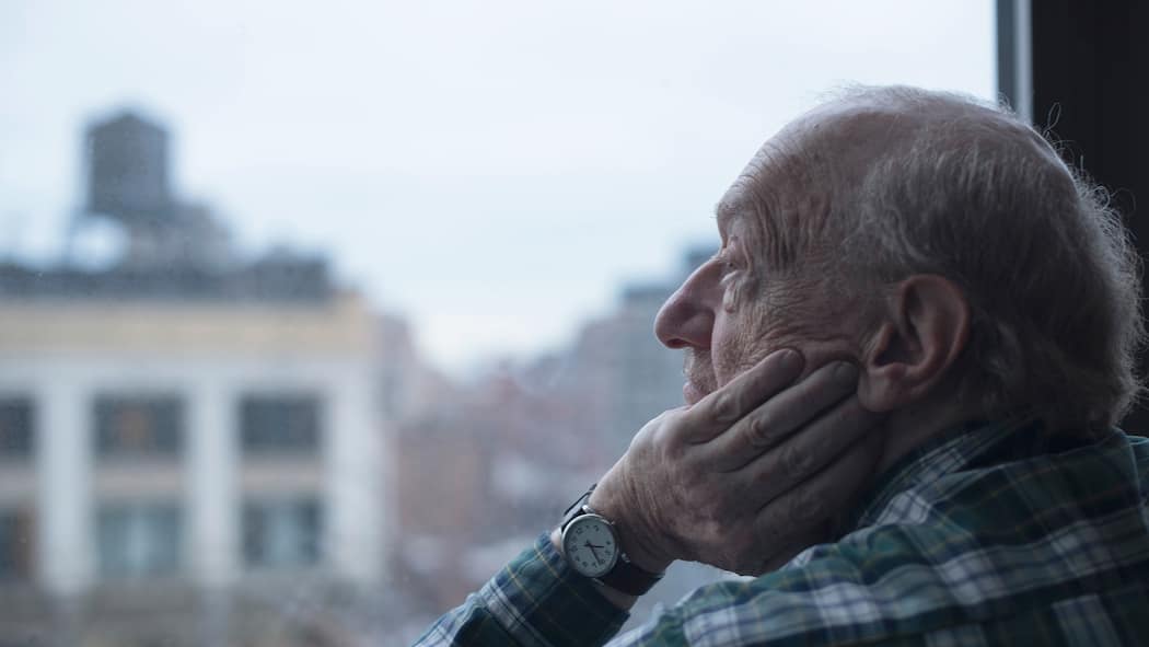«Ein zurückgezogenes Leben ist ein Risiko» Älterer Mann blickt nachdenklich aus dem Fenster