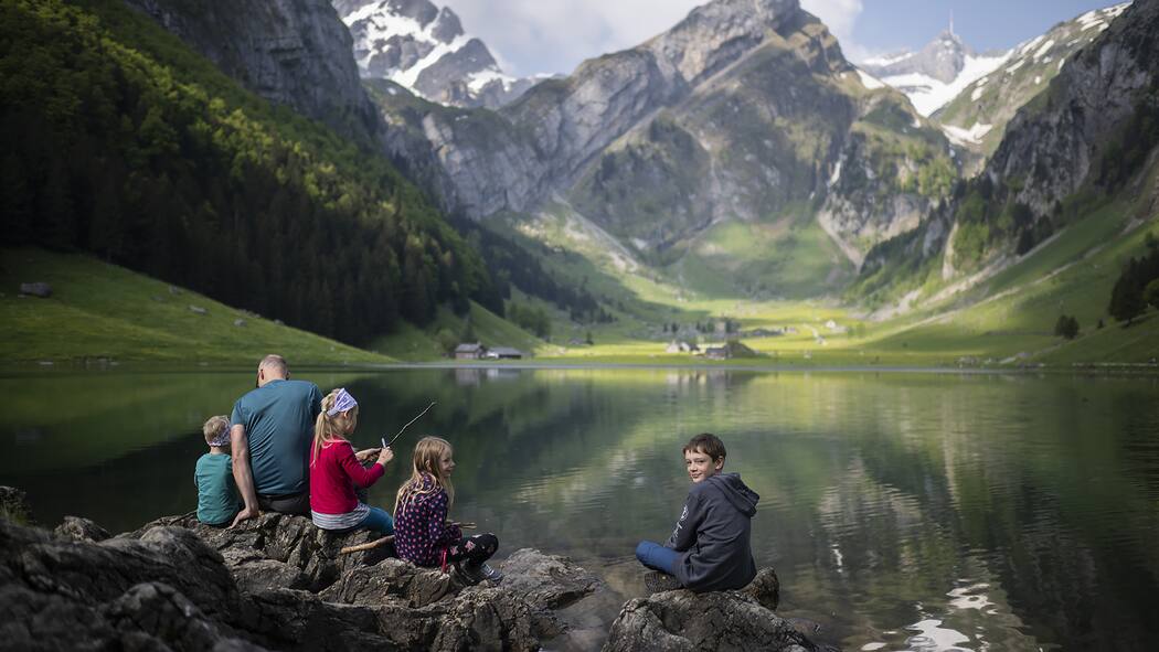 8 Tipps für stressfreie Wanderungen Familie sitzt am See - Damit die Kinder keine schlechte Laune beim Wandern bekommen, sollte man ein paar Punkte beachten