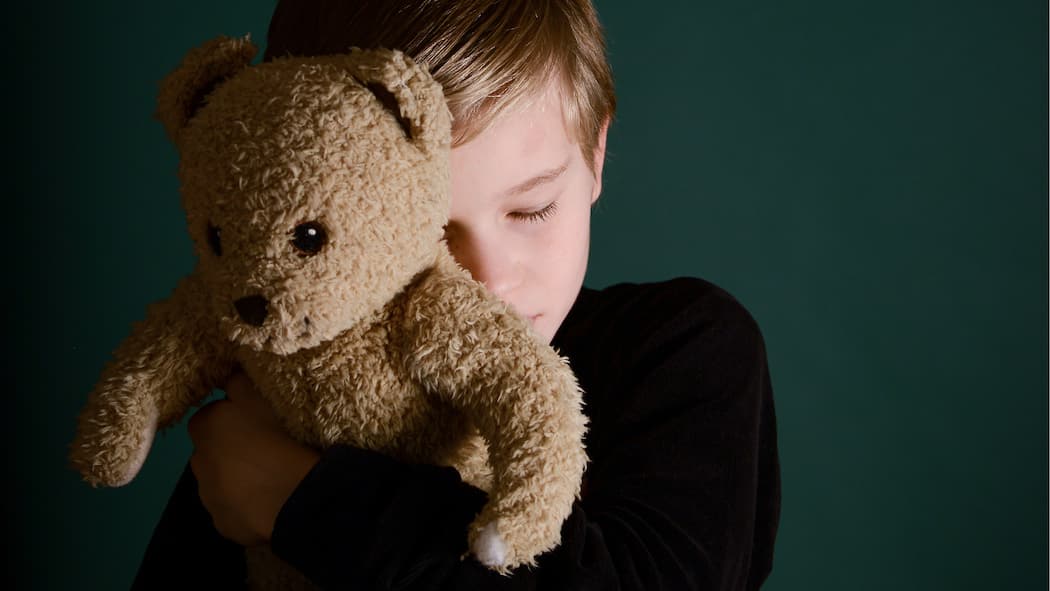 Wie Eltern sich einigen lernen Ein Junge drückt seinen Teddy fest an sich.