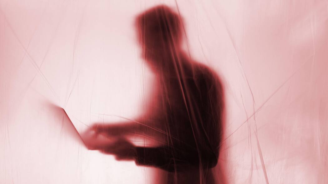 Die Schweiz schützt Whistleblower zu wenig Mann hinter einem Vorhang am Laptop: Whistleblower werden in der Schweiz wenig geschützt