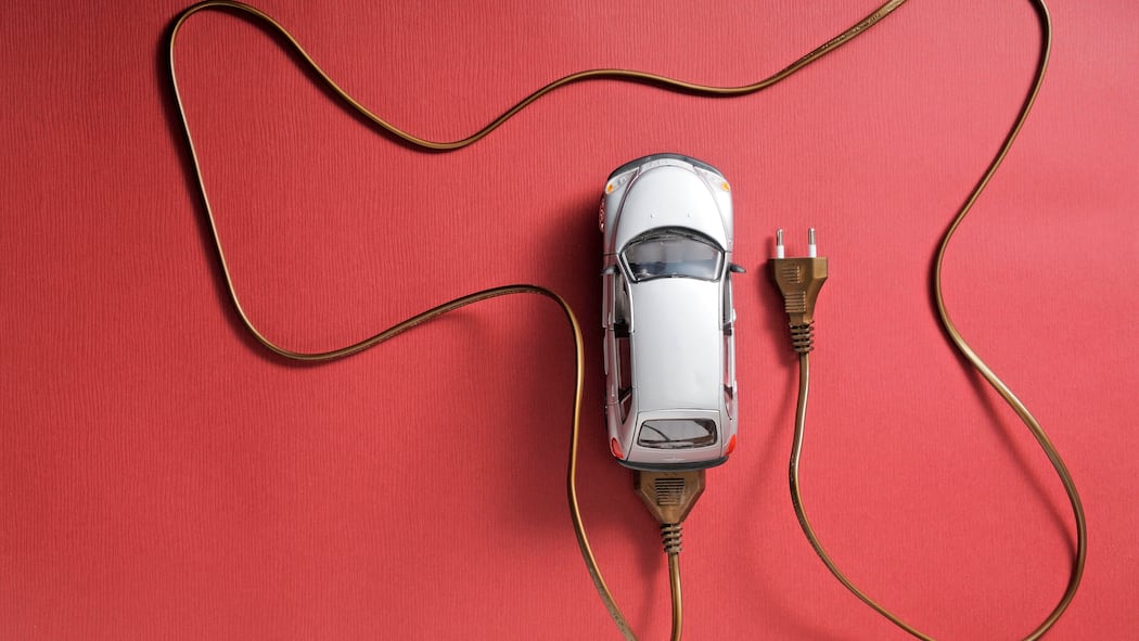 E-Auto mieten statt kaufen – lohnt sich das? Spielzeug-Auto das an einem Ladekabel angeschlossen ist