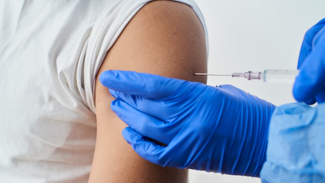 Werden die Nebenwirkungen ernst genug genommen? Eine Medizinfachperson verabreicht eine Impfung in den Oberarm.