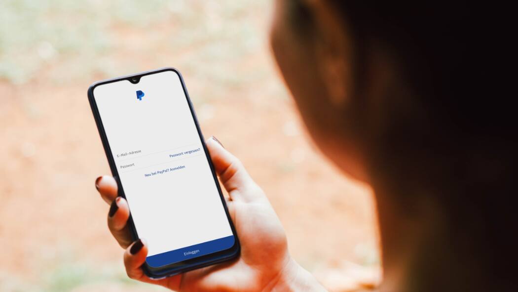 Raffinierter Trick: Kriminelle fordern Geld per Paypal Eine Frau loggt sich auf dem Smartphone bei Paypal ein.