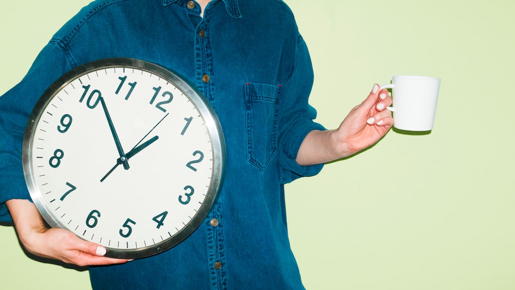 Ausstempeln fürs WC? Das gilt bei Arbeitspausen Eine Person mit Kaffeetasse in einer Hand und einer Wanduhr in der anderen Hand vor grünem Hintergrund. Wie Arbeitspausen in der Schweiz geregelt sind, legt das Arbeitsgesetz klar fest.