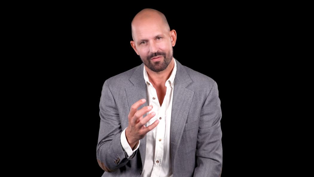 Er deckte Missstände im Spital auf Kandidat André Plass sitzt im weissen Hemd und grauer Anzugsjacke vor schwarzem Hintergrund.