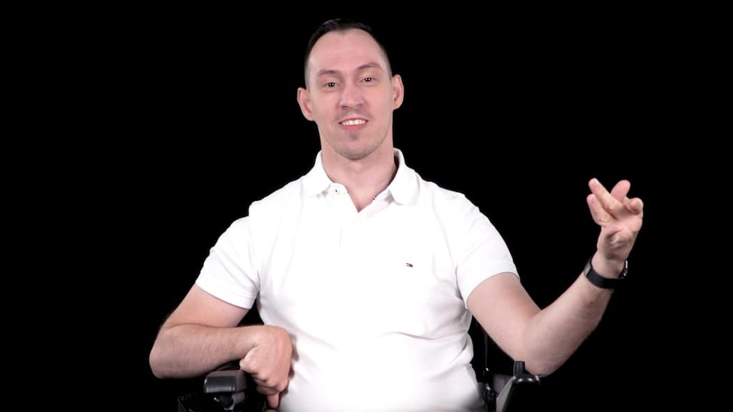 Er will Leute mit Handicap stärken Prix Courage 2021 Kandidat Islam Alijaj sitzt im weissen T-Shirt vor einem schwarzen Hintergrund.