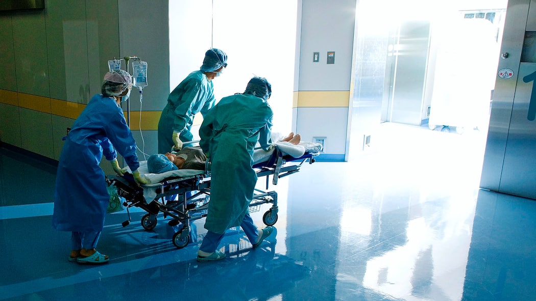 Wenn lieber vertuscht wird Eine Patientin im Bett wird von Spitalpersonal durch einen Gang gestossen