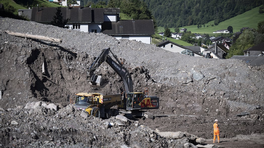 Jedes sechste Haus ist von einer Naturgefahr betroffen Bagger fuehren Schutt ab in Schwanden -