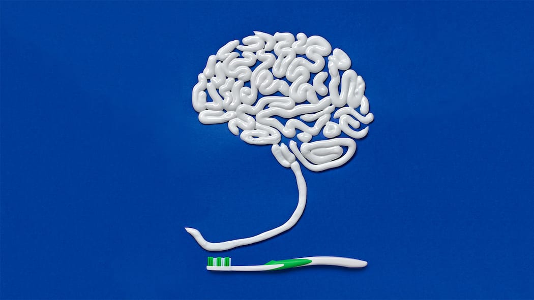 Gesundes Gehirn beginnt im Mund Ein stilisiertes Gehirn, auf ein Blatt Papier gemalt mit Zahnpasta.