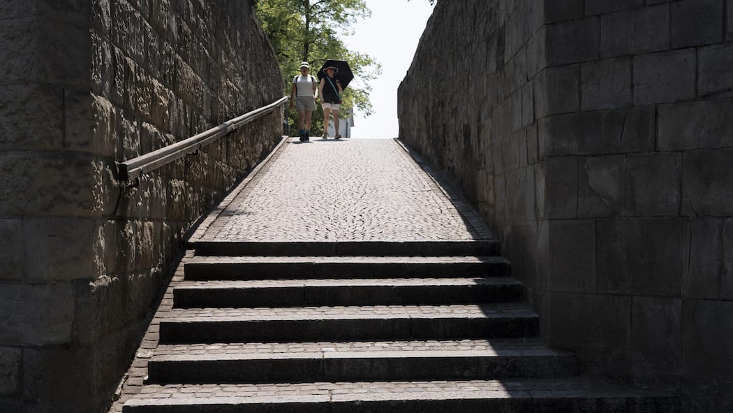 Ein «Vampir-Modus» entlarvt Zürichs Schattenseiten Zwei Personen, die die Treppe des Lindenhofs hinunterlaufen, fotografiert waehrend der Hitzewelle und der extremen Temperaturen um etwa 14:50 Uhr am Donnerstag, 30. Juli 2026, in Zuerich. KEYSTONE/Gaetan Bally)