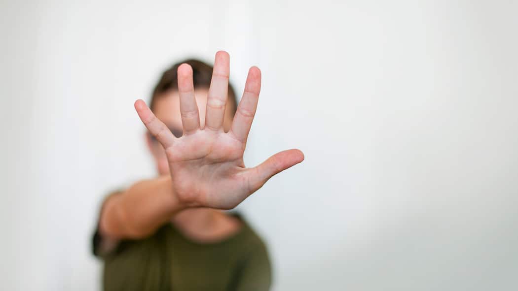 Wenn Hautkrankheiten die Psyche belasten Junge verdeckt Gesicht mit Hand