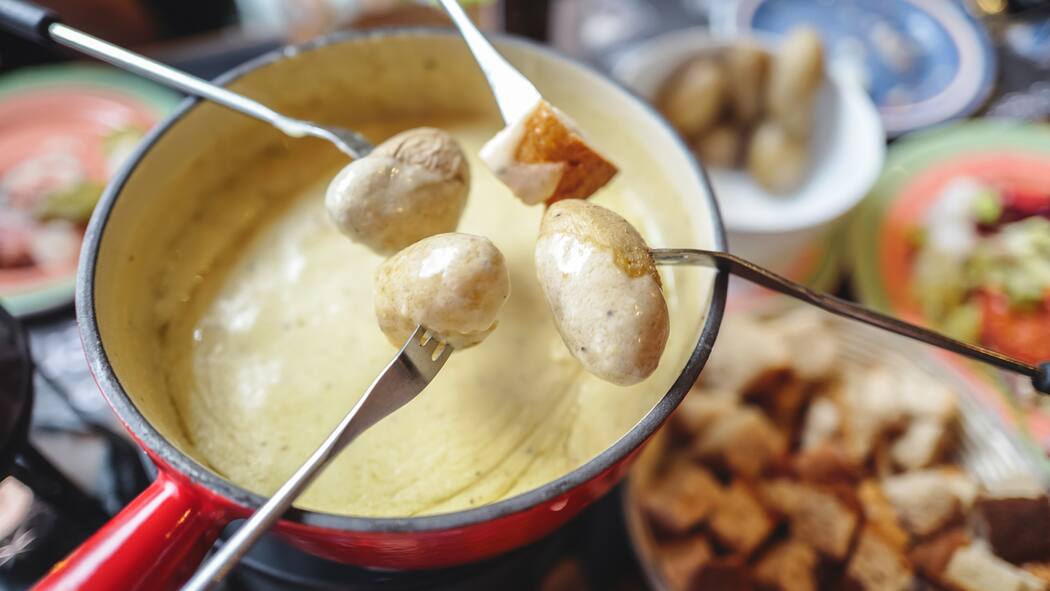 Der Online-Kritiker mit dem schlechten Gewissen Fonduegabeln über einer Schüssel Fondue