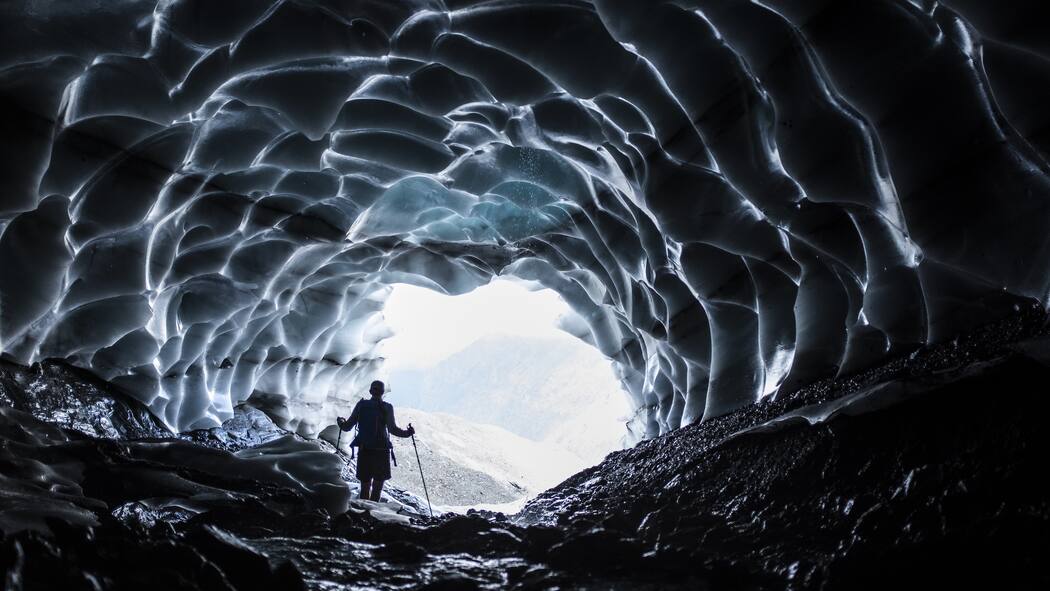 Macht die Hitze die Berge gefährlicher? Macht die Hitze die Berge gefährlich? Ein Mann wandert durch die Höhle des Sardonagletschers bei Vättis SG.